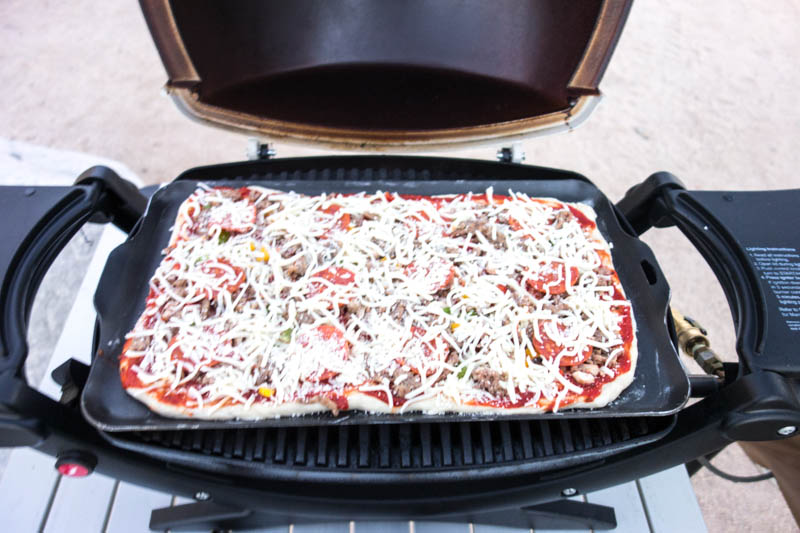 Place the Pizza in the Baby Q. Because of the pan, the temperature will drop to about 300-350 F (depending where you are camping). Bake it for about 15 minutes, or until the cheese starts to bubble. Since you made the dough very thin, it is now perfect.