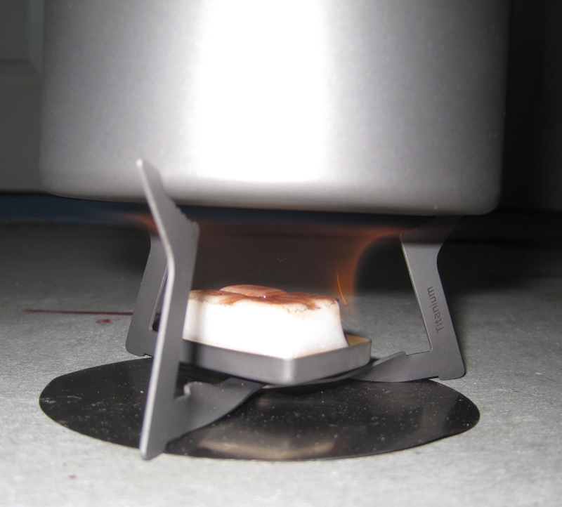 This is a popular Esbit stove that is supporting a pot in the photo. Not how close to the ground it is, also I have protected the ground with a piece of titanium foil, which a lot of people don't do.